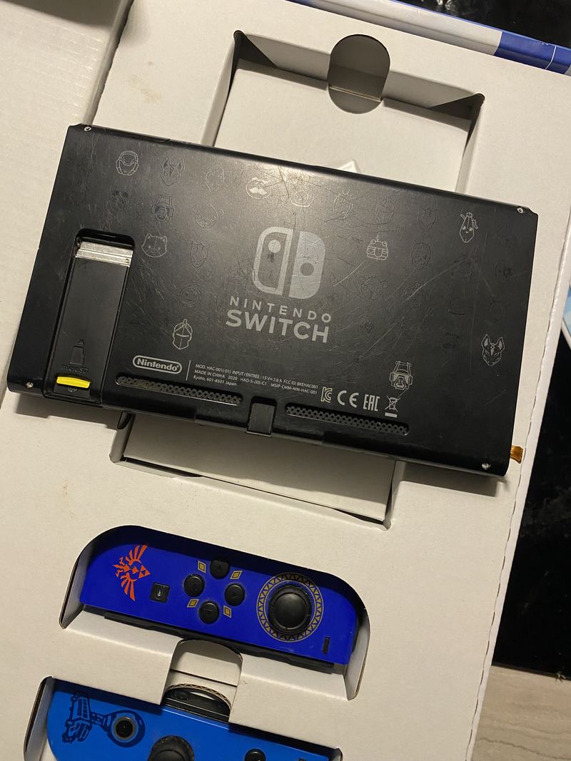 A Nintendo Switch console with its controllers detached, opened up on the bench for repair.