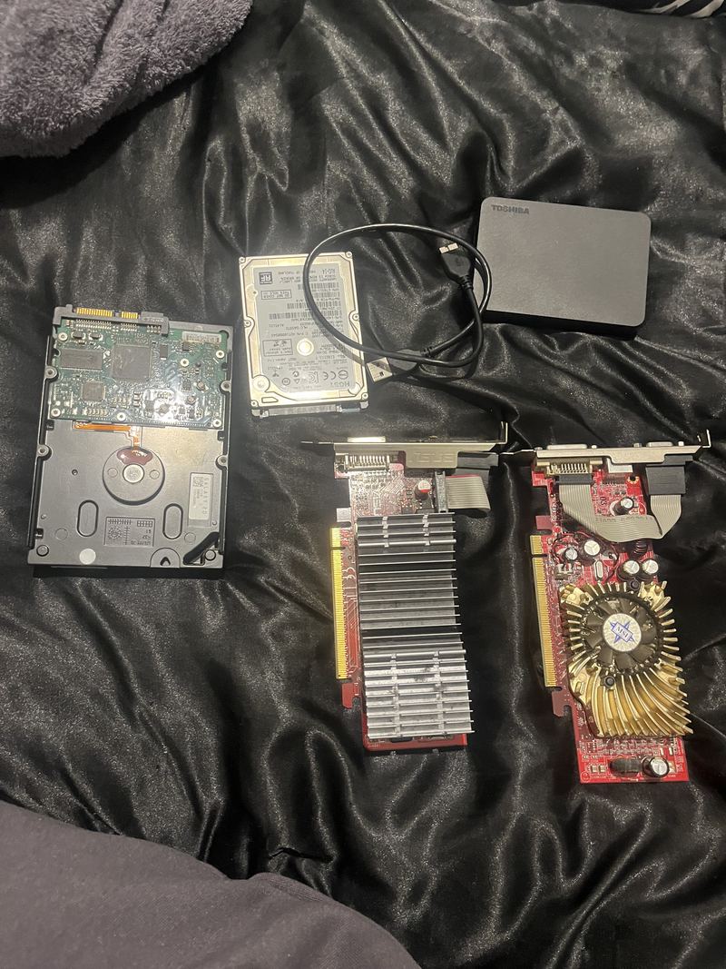 Two graphics cards, a 3.5-inch hard drive, a 2.5-inch drive and a portable external drive laid out together.