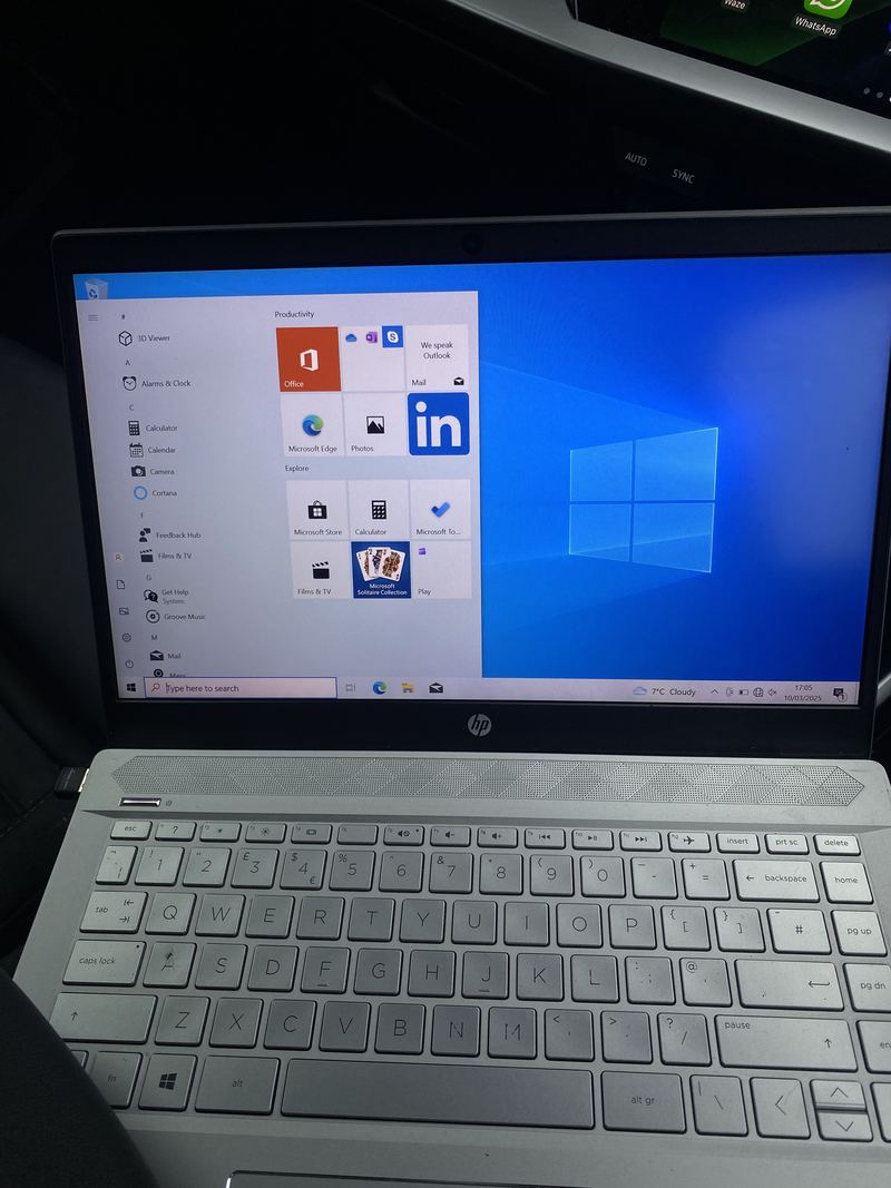 A laptop running through Windows setup, with the keyboard alongside.
