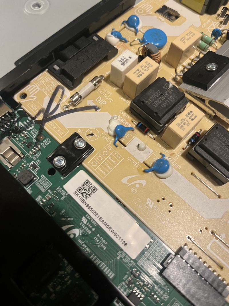 The power supply board inside a television, showing the mains fuse, capacitors and transformers.